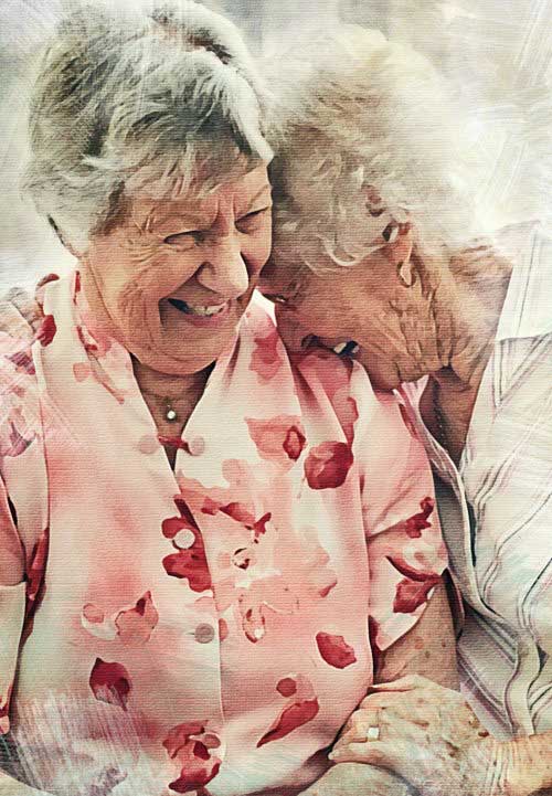 Two elderly women sharing a laugh together
