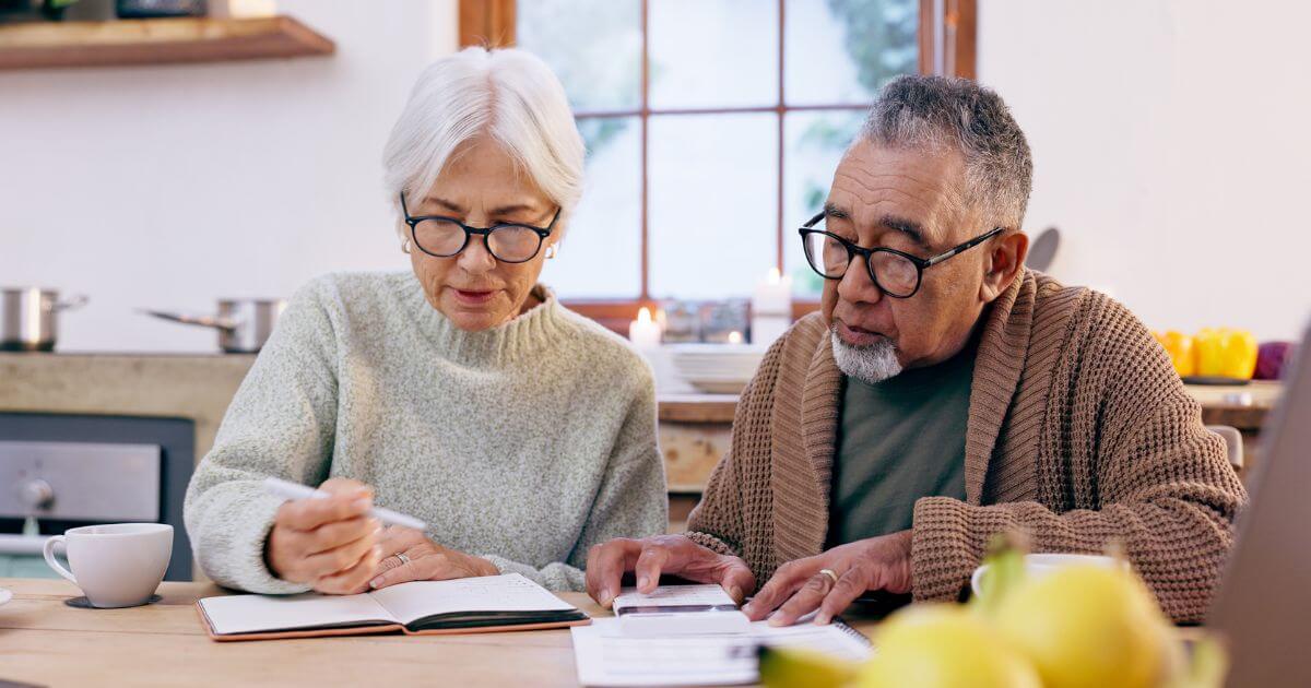 Senior couple at the table comparing the cost and value of assisted living.