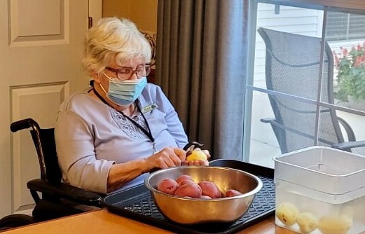 senior woman peeling potatoes
